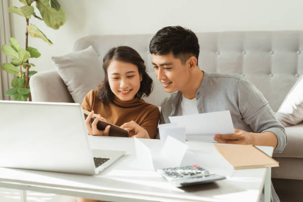 istock Processing online payment. Husband and wife processing online payment while shopping online 1207176873
