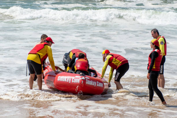 life savers training in progress. surf rescue boat surrounded by crew - surf rescue imagens e fotografias de stock