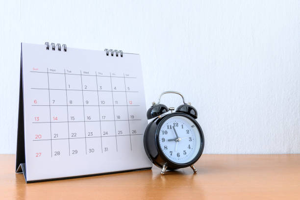 istock Calendar With Days and clock on wood table 1207184970