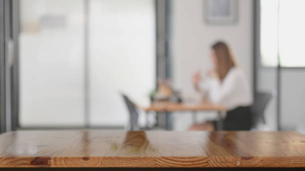 Close up view of copy space on wooden table with blurred co-working space