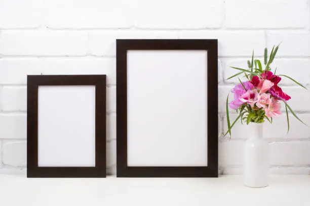 Photo of Two black brown poster frame mockup with pink clarkia flowers