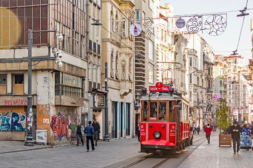 istiklal street,istanbul,turkey-february 18,touristy red nostalgic tram on istiklal street between modern and historical buildings with people and tourists.