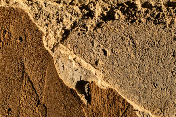 istock The cemented wall is grey and brown with texture and relief, the building material is old and battered 1207200544