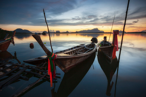 Beautiful sunset of fishing village in Phang Nga Bay with longtail wooden fishing  boat ,Thailand