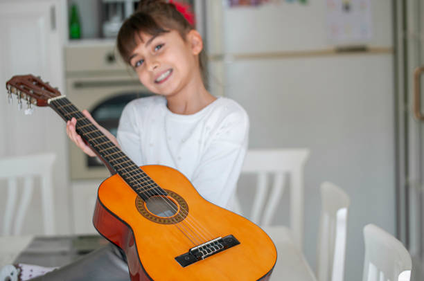 istock Cute girl playing guitar 1207203513