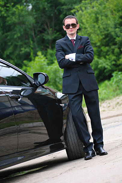 istock man with glasses and suit stand near to expensive car 120720439