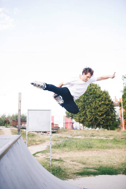 istock man roller skating on rollers makes a trick jump from the pedestal 1207204800