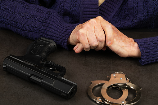 Close up photo of a handcuffed elderly woman