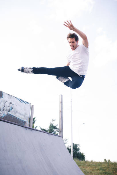 istock man roller skating on rollers makes a trick jump from the pedestal 1207205245