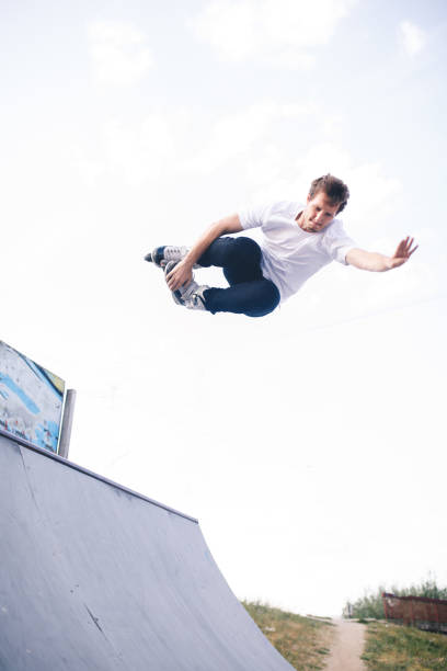 istock man roller skating on rollers makes a trick jump from the pedestal 1207205315