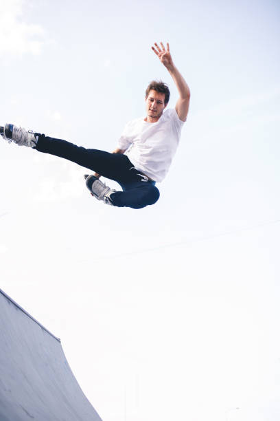 istock man roller skating on rollers makes a trick jump from the pedestal 1207205349