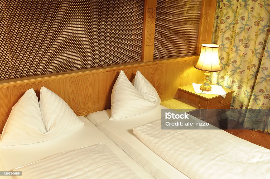 Double bed in hotel room Comfortable wooden double bed in hotel room with white pillows and quilts Bed - Furniture Stock Photo