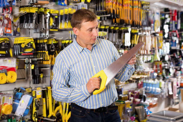 istock Confident man is choosing bucksaw in tools store 1207210476