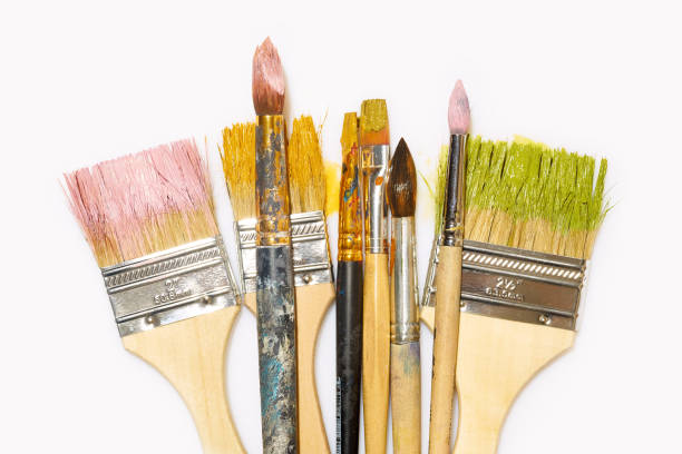 istock Various artistic brushes with paint on white background. Messy creative equipment. 1207213471