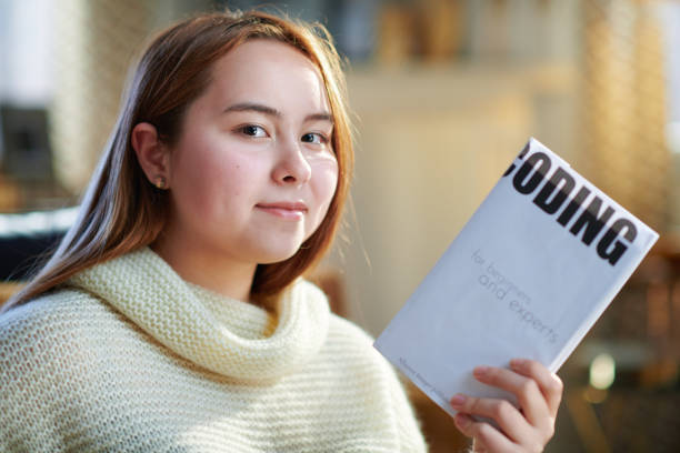 istock happy modern teenager girl holding educational coding book 1207215829