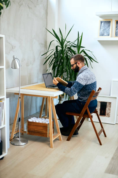 istock Attractive freelancer sitting in modern office reading. 1207217975