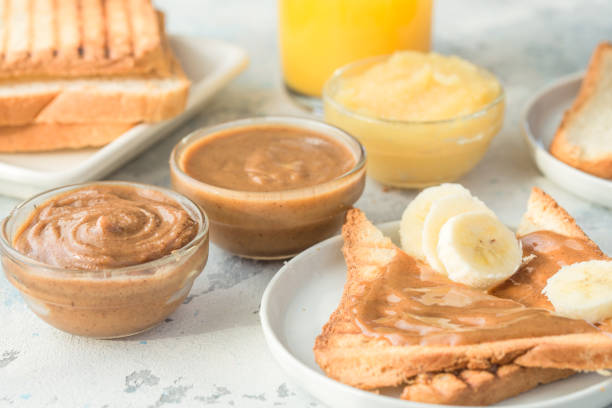 istock Nut butter and bread toast on white plate. Assorted nut butter spread on white toast bread. Healthy eating, vegan, vegetarian, healthy lifestyle, nutrition concept 1207218084
