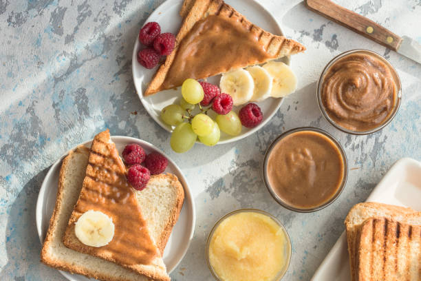 istock Nut butter and bread toast on white plate. Assorted nut butter spread on white toast bread. Healthy eating, vegan, vegetarian, healthy lifestyle, nutrition concept 1207218090