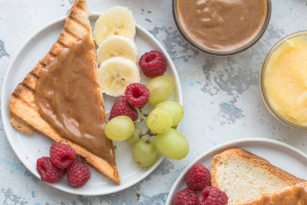 istock Nut butter and bread toast on white plate. Assorted nut butter spread on white toast bread. Healthy eating, vegan, vegetarian, healthy lifestyle, nutrition concept 1207218101