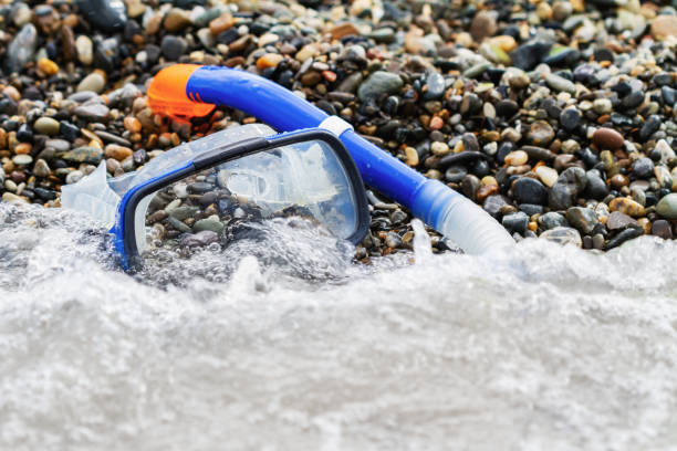 istock Blue snorkel and mask for diving on the pebble beach 1207218292