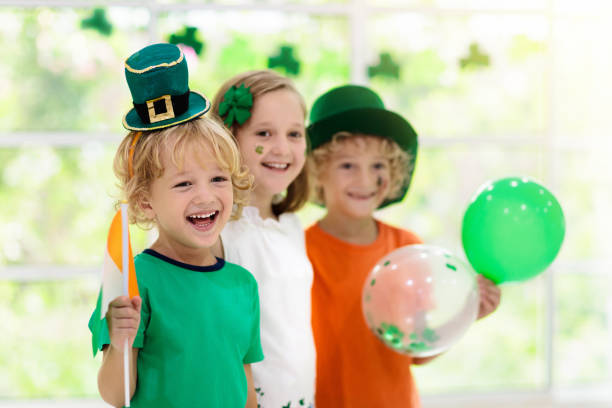Kids celebrate St Patrick Day. Irish holiday. Family celebrating St. Patrick's Day. Irish holiday, culture and tradition. Kids wear green leprechaun hat and beard with Ireland flag and clover leaf. Children having fun at St Patrick party. st. patricks day stock pictures, royalty-free photos & images