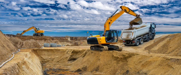 excavator auf baustelle - graben körperliche aktivität stock-fotos und bilder