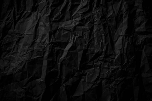 istock Dark black crumpled paper close up texture background 1207219510