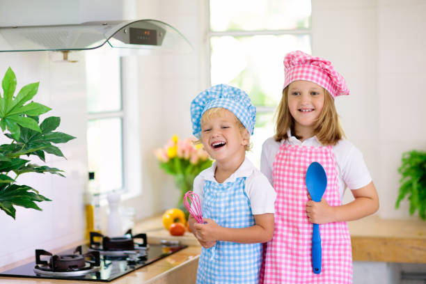 istock Kids cook in white kitchen. Children cooking. 1207225268