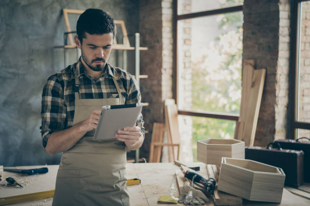 istock Focused professional hardwood worker use his smart tablet check clients orders offers in house home garage 1207229137