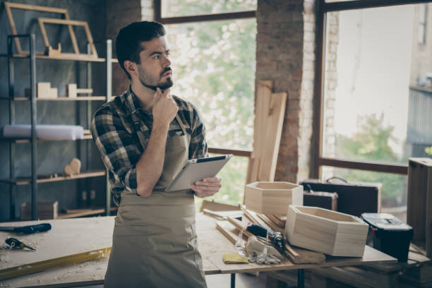 istock Minded pensive hardwood foreman professional workman use tablet think decide choose clients repair restoration orders offers in home house garage 1207229196