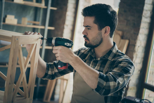 istock Profile photo of handsome guy building book shelf handmade design assembling using drill wooden industry home woodwork workshop indoors 1207231185