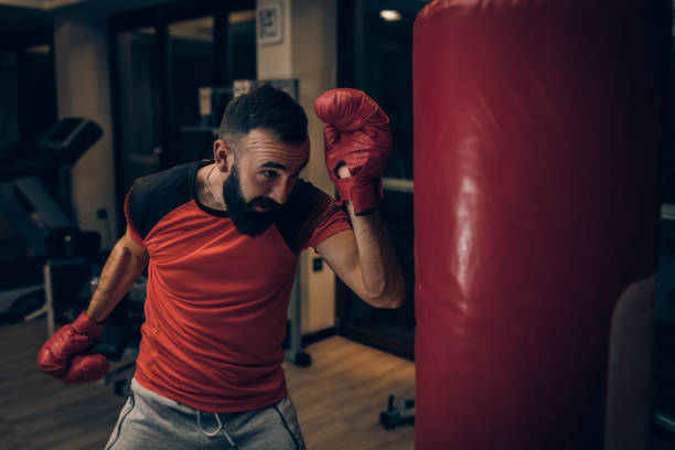 istock Young bearded man kickboxing in the gym 1207231374
