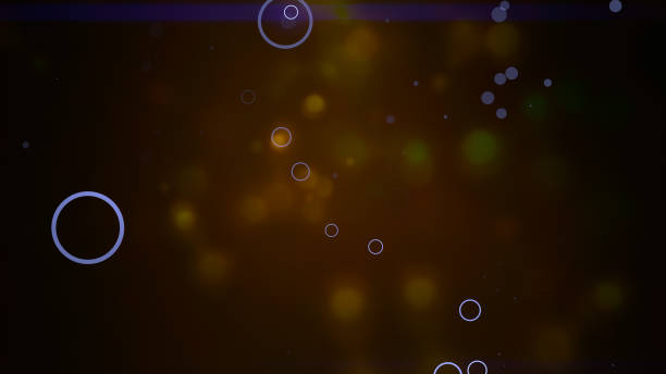 istock Bokeh particles float and glisten over dark background with depth of field. 1207232473