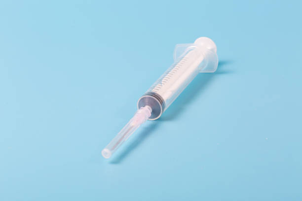 istock Macro closeup of syringe on blue background 1207232621