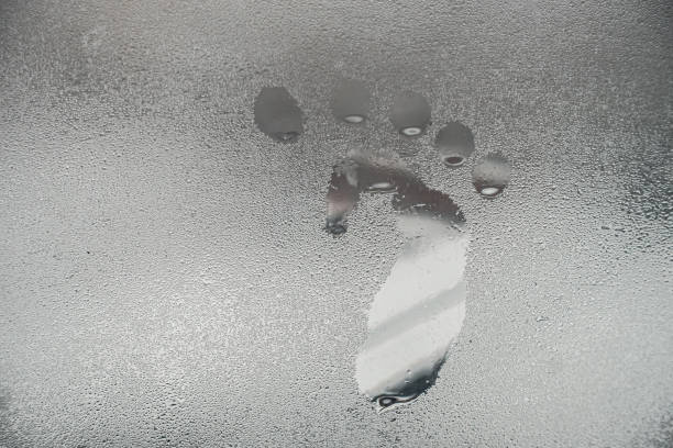 footprints on frozen window。steam imprint on the window - condensation steam window glass imagens e fotografias de stock