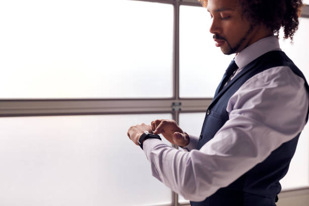 istock Businessman Wearing Suit Looking At Smart Watch In Office 1207237255