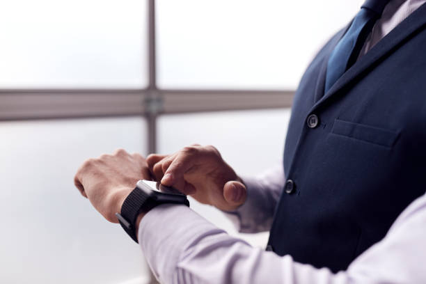 Close Up Of Businessman Wearing Suit Looking At Smart Watch Close Up Of Businessman Wearing Suit Looking At Smart Watch smart watch business stock pictures, royalty-free photos & images