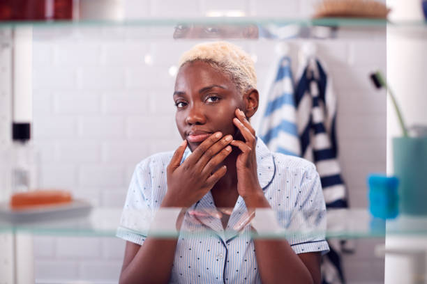 istock View Through Bathroom Cabinet Of Young Woman Squeezing Spot Before Going To Work 1207246602