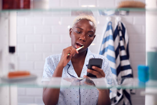 istock View Through Bathroom Cabinet Of Woman Brushing Teeth And Checking Phone Before Going To Work 1207246779