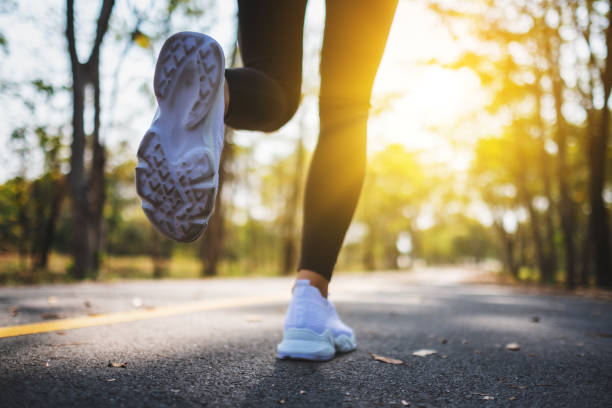 istock a woman's legs while jogging in city park in the morning 1207247304