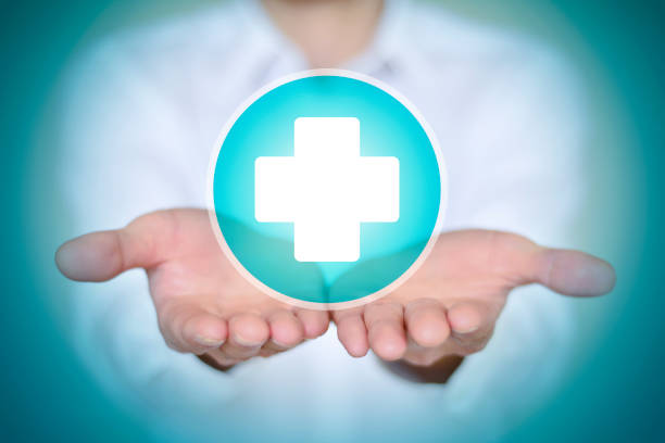 Close-up man in white shirt holding white first aid icon.