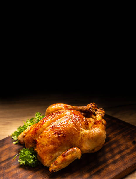 istock Roasted whole chicken on wooden cutting board. 1207249551