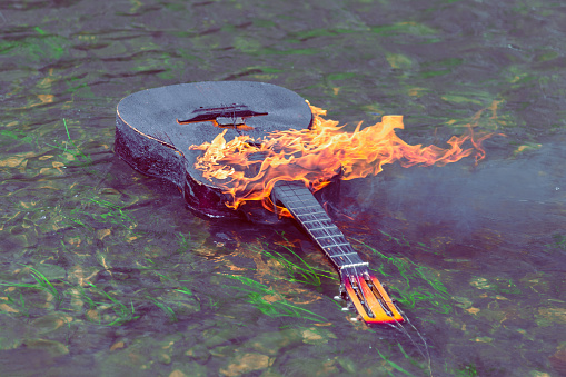 burning acoustic guitar floats on water