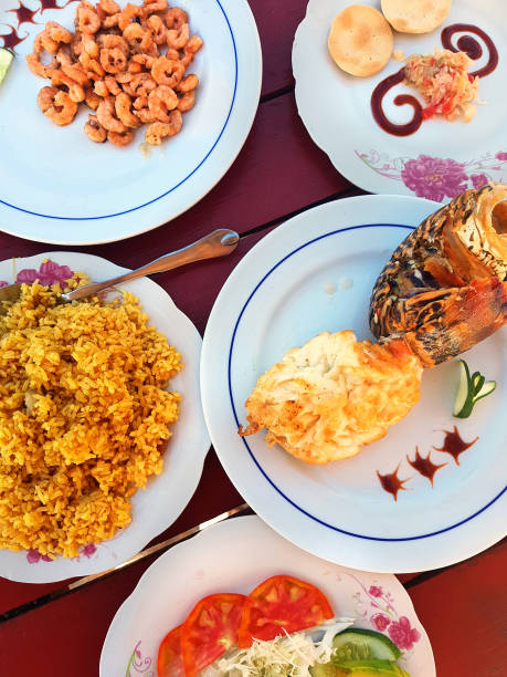 istock Grilled lobster on a plate along, shrimps, vegetables and rice 1207251040