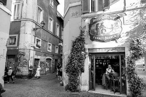 Rome, Italy, May 25 - Rome in Black & White series. A view of a typical alley in Trastevere, in the heart of Rome, with the facade of the Antico Caffe del Moro, a ancient coffee shop of Rome.