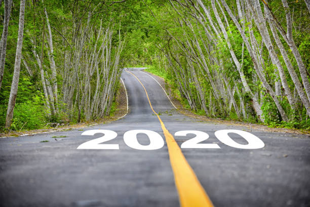istock Tree tunnel with number 2020 on asphalt road surface 1207255356