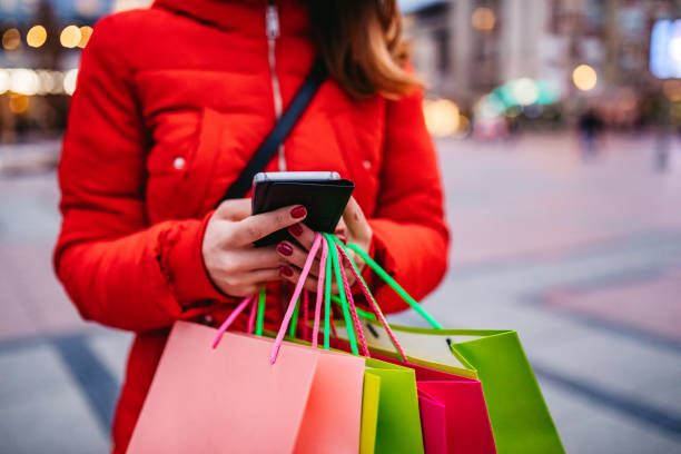 istock Woman with shopping bags using phone 1207255359
