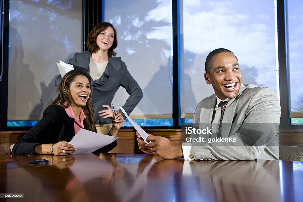 Multiracial businesspeople watching presentation Multiethnic office workers in boardroom watching presentation, laughing, focus on man 20-29 Years Stock Photo