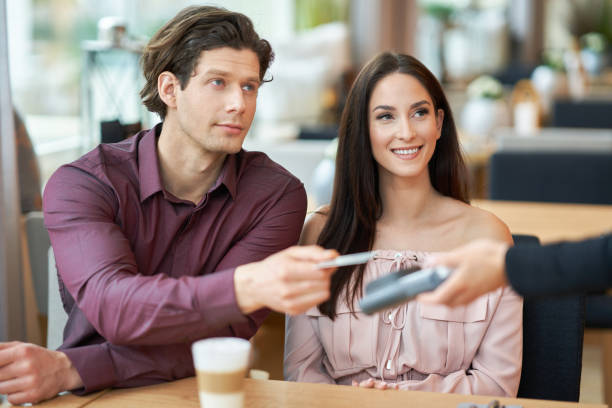 istock Young Couple paying by credit card in Cafe 1207256624