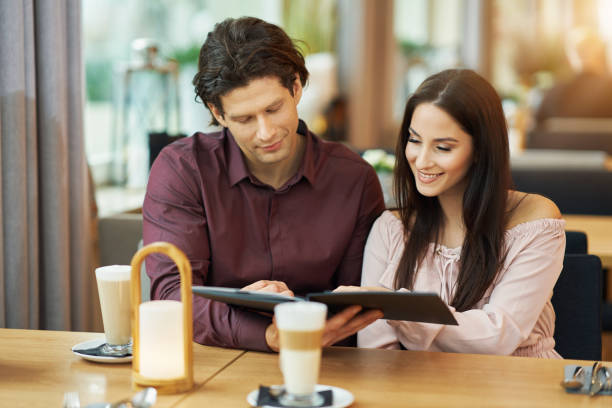istock Young Couple looking at menu In Cafe 1207257741